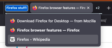 A collapsed Firefox tab group is hovered, showing a dropdown listing three tabs in a group labeled “Firefox stuff!” The results include “Download Firefox for Desktop — from Mozilla,” “Firefox browser features — Firefox” (currently open), and “Firefox - Wikipedia.”
